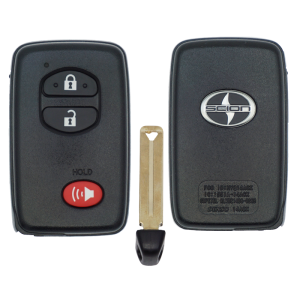 Pair of black Scion car key fobs with a metal key blade between them; left fob shows lock, unlock, and red panic button, right fob bears the Scion logo.